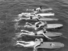 Мужчины плывут на досках для серфинга