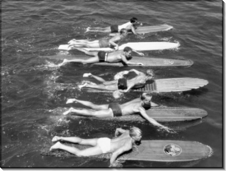 Мужчины плывут на досках для серфинга